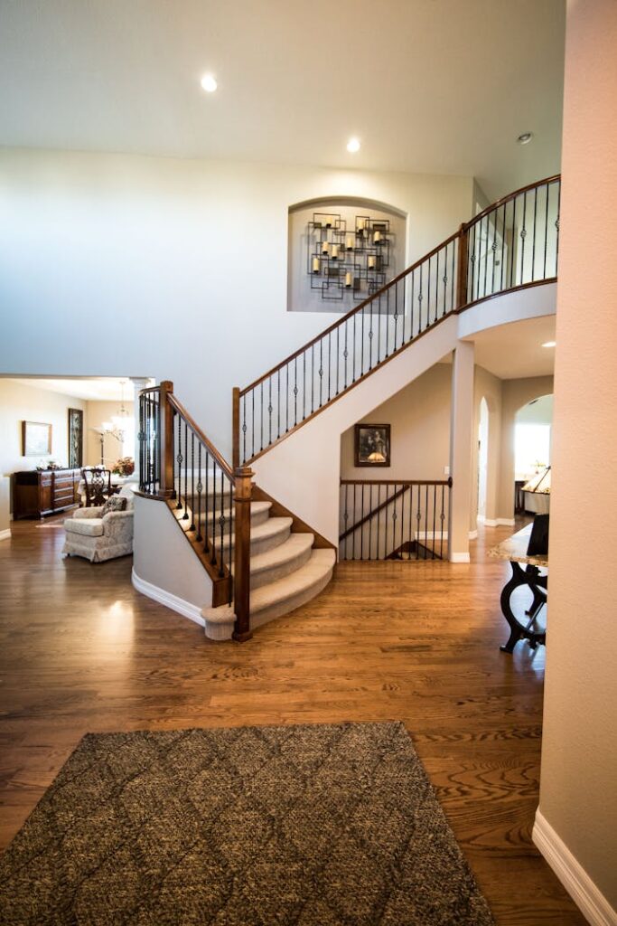 pexels-photo-2121121-1 Spacious modern interior showcasing a stylish wooden staircase and elegant decor.