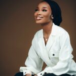 Elegant portrait of a smiling woman in business attire, exuding confidence and style.